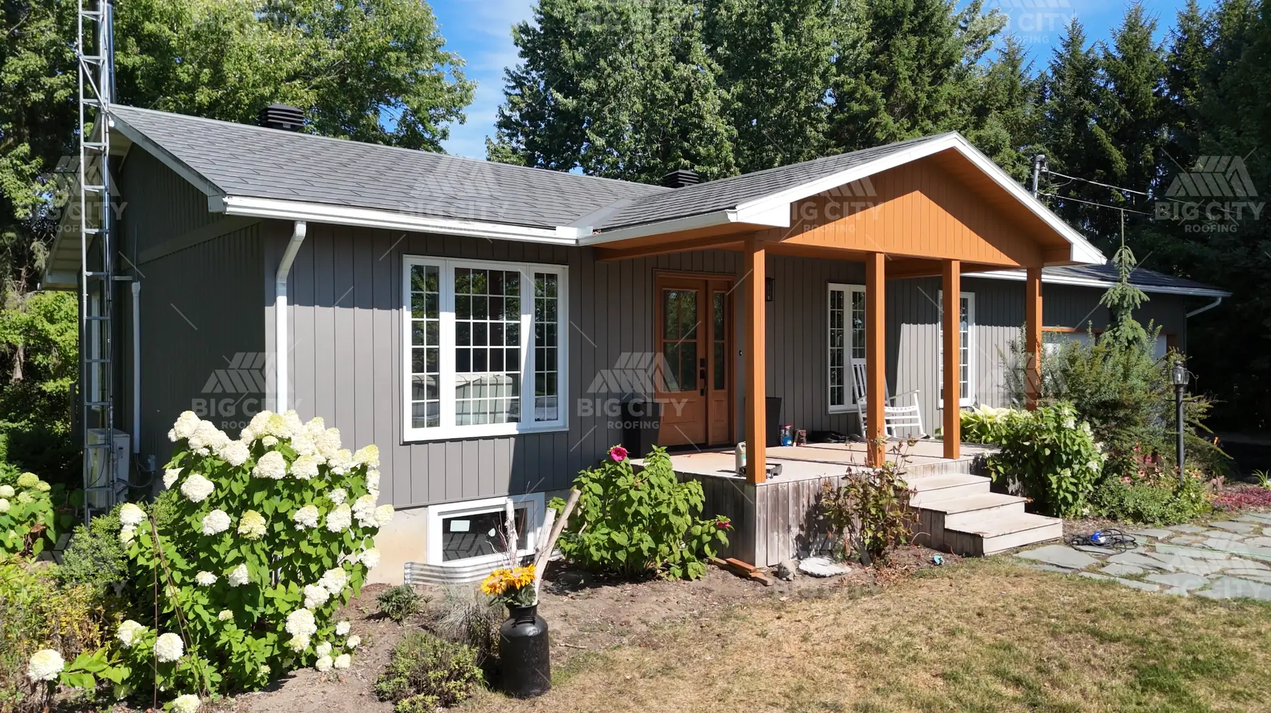The same home after installation of grey board and batten siding